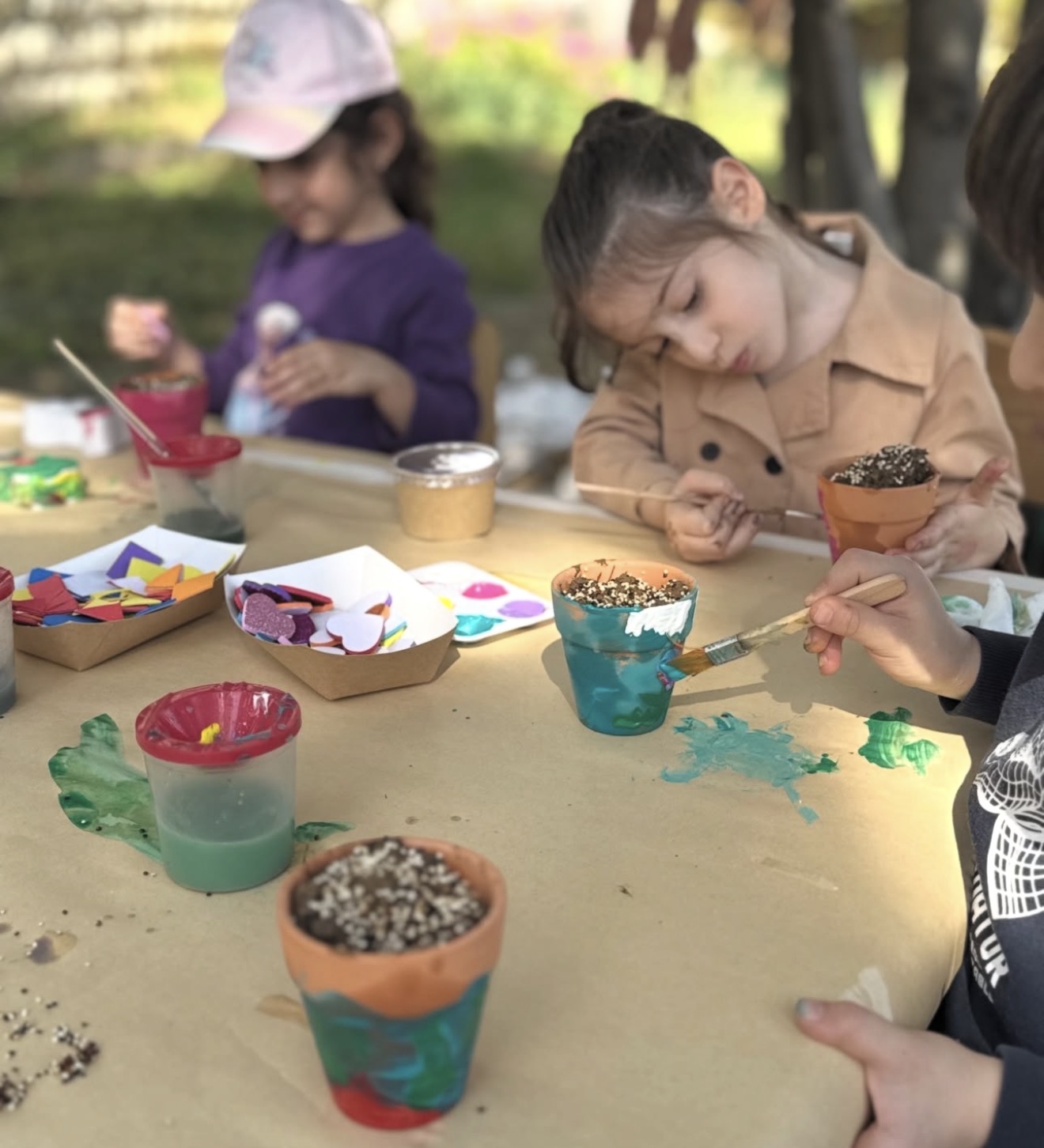 Kids decorating clay pots and planting seeds